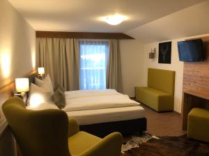 een hotelkamer met een bed en een stoel bij Gasthof Hirschen in Reith bei Seefeld