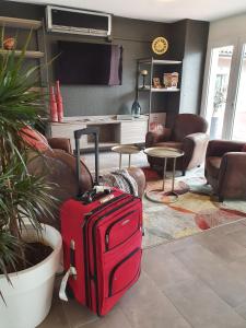 a red suitcase is sitting in a living room at Hôtel Saint Louis in Le Thor