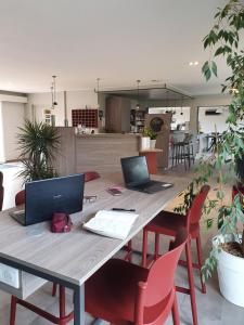 a table with two laptops on top of it at Hôtel Saint Louis in Le Thor