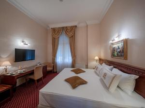 Habitación de hotel con cama grande y escritorio. en Hotel Waldinger, en Osijek
