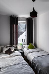 two beds in a room with a window at Apartament Szczęśliwy in Ustrzyki Dolne
