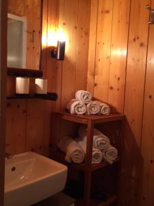 a bathroom with a shelf with towels and a sink at Gaestehaus-Russegger in Abtenau