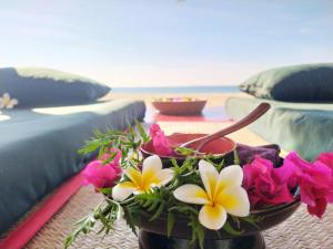 a table topped with flowers on top of a room at Emerald Sea Resort in Ngwesaung