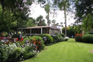 una casa en un jardín con flores y plantas en Montagu Springs Resort, en Montagu