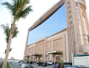 un edificio con una palmera delante de él en Casablanca Grand Hotel en Yeda