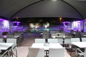 a restaurant with tables and chairs and purple lights at Hôtel Saint Louis in Le Thor +102 photos