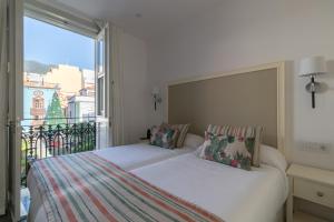 a bedroom with two beds and a large window at Hotel Emblemático Holiday Time in Santa Cruz de la Palma