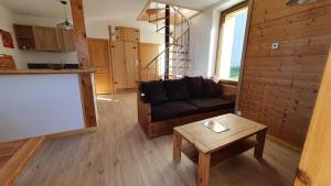 ein Wohnzimmer mit einem Sofa und einem Tisch in der Unterkunft Le Rebiolon in La Chapelle-Blanche