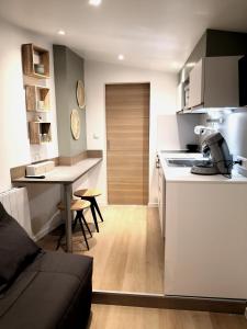 a kitchen and living room with a couch and a table at Le cabanon in Méneslies