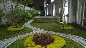 un jardín frente a un edificio con una pasarela en Ruby Apartment #1, en Yogyakarta