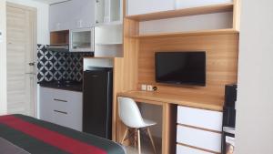 Una pequeña cocina con un escritorio y un televisor en una habitación. en Ruby Apartment #1, en Yogyakarta