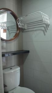 un baño con inodoro y espejo en Ruby Apartment #1, en Yogyakarta 6 fotos más