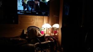 a dark room with a chair and a tv on a wall at Chalet Die Berghexn in Klippitztorl