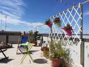 a patio with potted plants and a table on a roof at B&B Stupor Mundi in Altamura