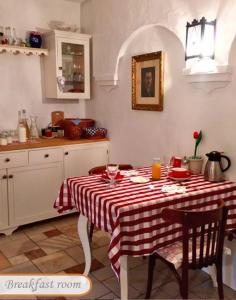 cocina con mesa y mantel rojo y blanco en B B Guesthouse TIHANY en Tihany