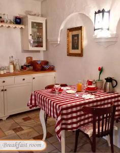 a kitchen with a table with a red and white table cloth at B B Guesthouse TIHANY in Tihany