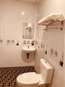 ein weißes Bad mit einem WC und einem Waschbecken in der Unterkunft Hoàng Hà Hotel in Tuy Hoa