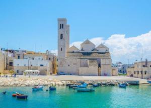 a group of boats in the water in front of a building at La Maison apartment Puglia in Molfetta
