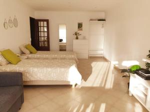 - une chambre avec deux lits et un canapé dans l'établissement Sunny Setúbal Apartments, à Setúbal