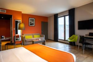 een hotelkamer met een bed en een bank bij Adonis Lyon Dock Ouest in Lyon