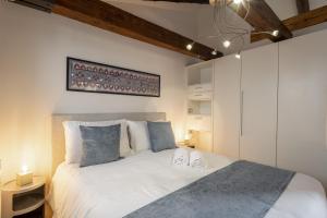 - une chambre avec un grand lit blanc et des oreillers bleus dans l'établissement Ve.N.I.Ce Cera Ca' Corte Sconta, à Venise