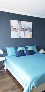 - une chambre avec un lit bleu et des oreillers bleus dans l'établissement Sunny Setúbal Apartments, à Setúbal