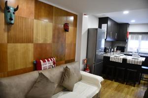ein Wohnzimmer mit einem Sofa und einer Küche in der Unterkunft Apimonte City House B in Bragança
