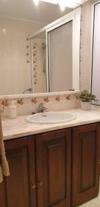 La salle de bains est pourvue d'un lavabo et d'un miroir. dans l'établissement Sunny Setúbal Apartments, à Setúbal