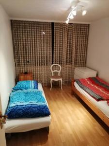 a bedroom with two beds and a chair in it at Großes PANORAMA APARTMENT mit POOL in Bingen am Rhein