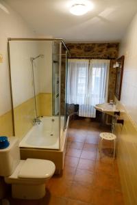 a bathroom with a tub and a toilet and a sink at Casa da Balea in Corcubión