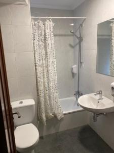 y baño con aseo, lavabo y ducha. en Hostal Uría, en Salamanca