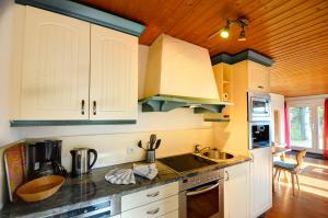 a kitchen with white cabinets and a sink at Ferienhaus am Feldberg in Feldberg