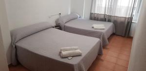 pokój z 2 łóżkami i ręcznikami w obiekcie Plaza de España w Salamance