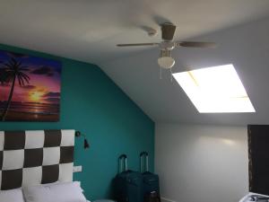 un ventilador de techo en un dormitorio con equipaje en Apartamentos El Volante II, en Ciempozuelos