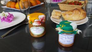 two bottles of honey and a plate of bread on a table at La Perle Marine in Saint-Leu