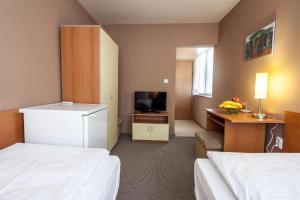 een hotelkamer met 2 bedden en een televisie bij Panorama Top Floor Rooms in Hotel Tundzha in Yambol