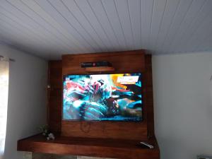 TV de pantalla plana en la parte superior de una pared en Casa do scur, en Canela