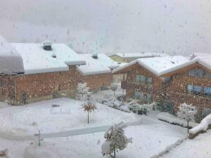 dom pokryty śniegiem na podwórku w obiekcie Grossglockner Alpin Lodge w mieście Matrei in Osttirol