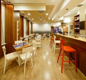 a restaurant with tables and chairs and a bar at Hotel Santa Rosa, Blue Hoteles in Gijón