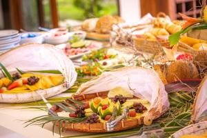 a table topped with baskets of fruits and vegetables at Refúgios Parajuru - Villa Cacau in Parajuru