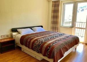 a bedroom with a large bed with a large window at Takhi Resort Terelj in Yoliin Hural