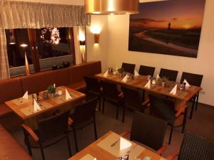 a dining room with wooden tables and chairs at Hotel das Möwenstübchen in Wremen