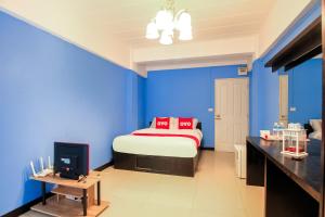 Schlafzimmer mit blauen Wänden und einem Bett mit roten Kissen in der Unterkunft Super OYO 427 Chill Apartment in Bangkok
