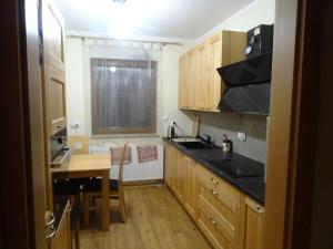 a kitchen with wooden cabinets and a table and a window at Apartament w centrum, garaż i jakuzzi w cenie in Wrocław