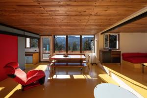 ボルカ・ディ・カドーレにあるChalet Dolomiti 430のリビングルーム(赤いソファ、テーブル付)