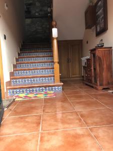 Habitación con escalera y suelo de baldosa. en Pensión Xacobe, en Cabreiros