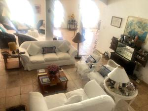 a living room with white couches and a table at Villa Saint Tropez in Cabo Frio