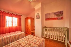 sypialnia z 2 łóżkami pojedynczymi i łóżeczkiem dziecięcym w obiekcie VILLA IRENE w mieście Fuenteheridos