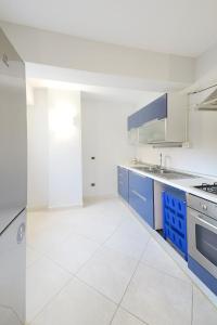 una cucina con armadi blu e pavimento piastrellato bianco di Domus Antonia a Castellammare di Stabia