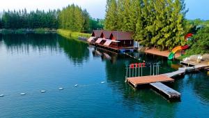 una casa en un lago con un muelle en el agua en Tara Beach Resort Udonthani, en Udon Thani